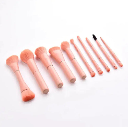 Set of pink makeup brushes on a white background