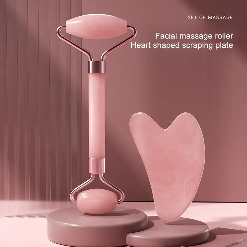 Facial massage roller with heart-shaped scraping plate on a pink background