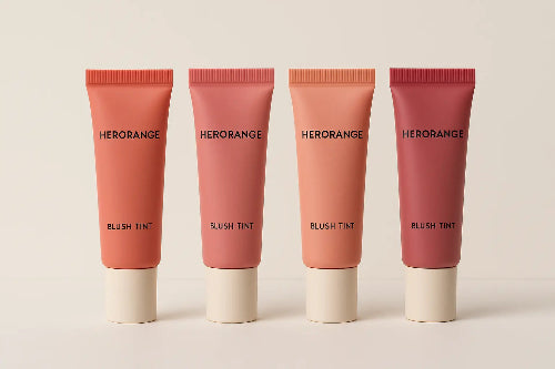 Four Herorange blush tint tubes on a beige background