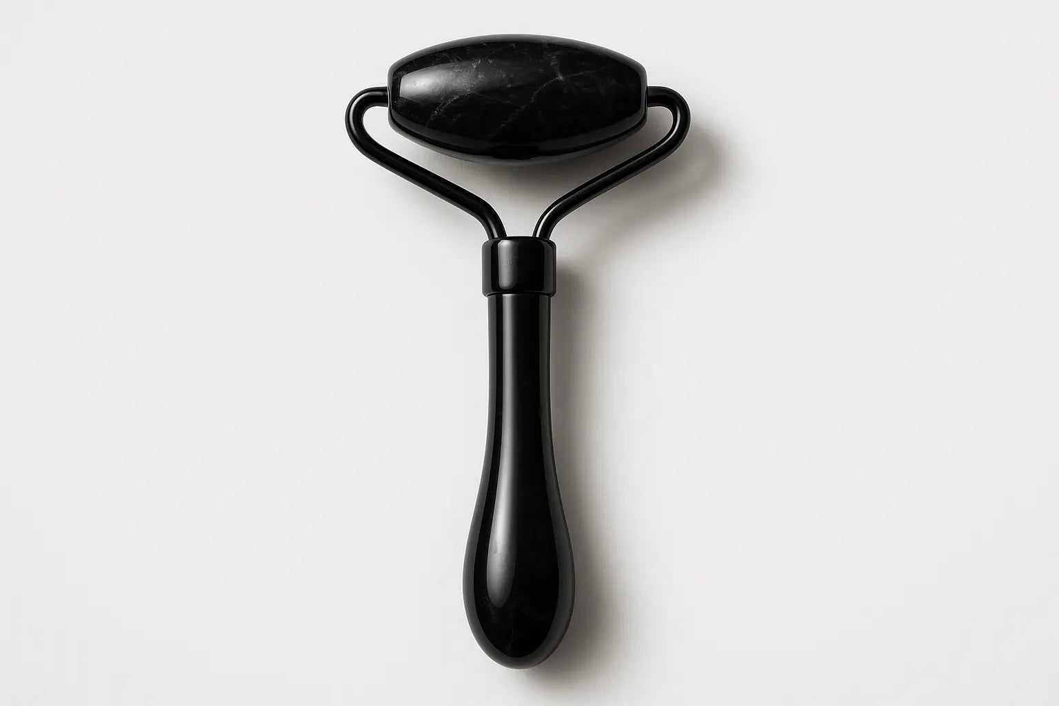 Black facial roller on a white background
