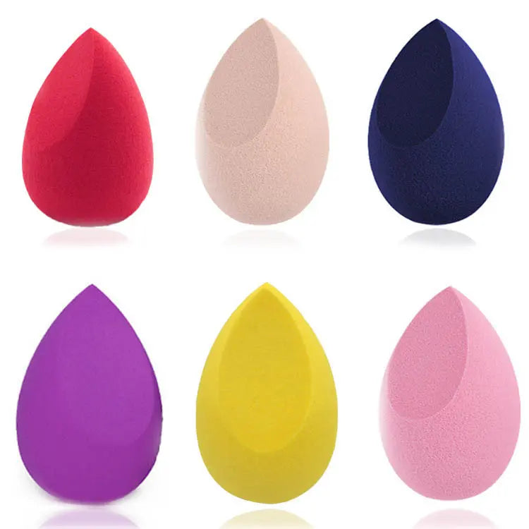 Set of six colorful makeup sponges on a white background